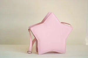 Pink star-shaped Lolita messenger bag three-quarter side angle view, showing neat stitching edges and adjustable shoulder strap detail on white background