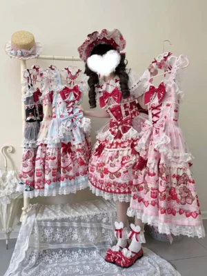Pink strawberry print sweet lolita JSK dress worn by model in boutique setting with ruffled straps and matching bonnet