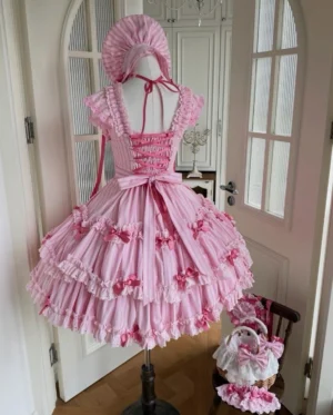 Back view of pink striped Lolita jumper skirt dress showing lace-up closure, large waist bow, and layered ruffled tiered skirt design