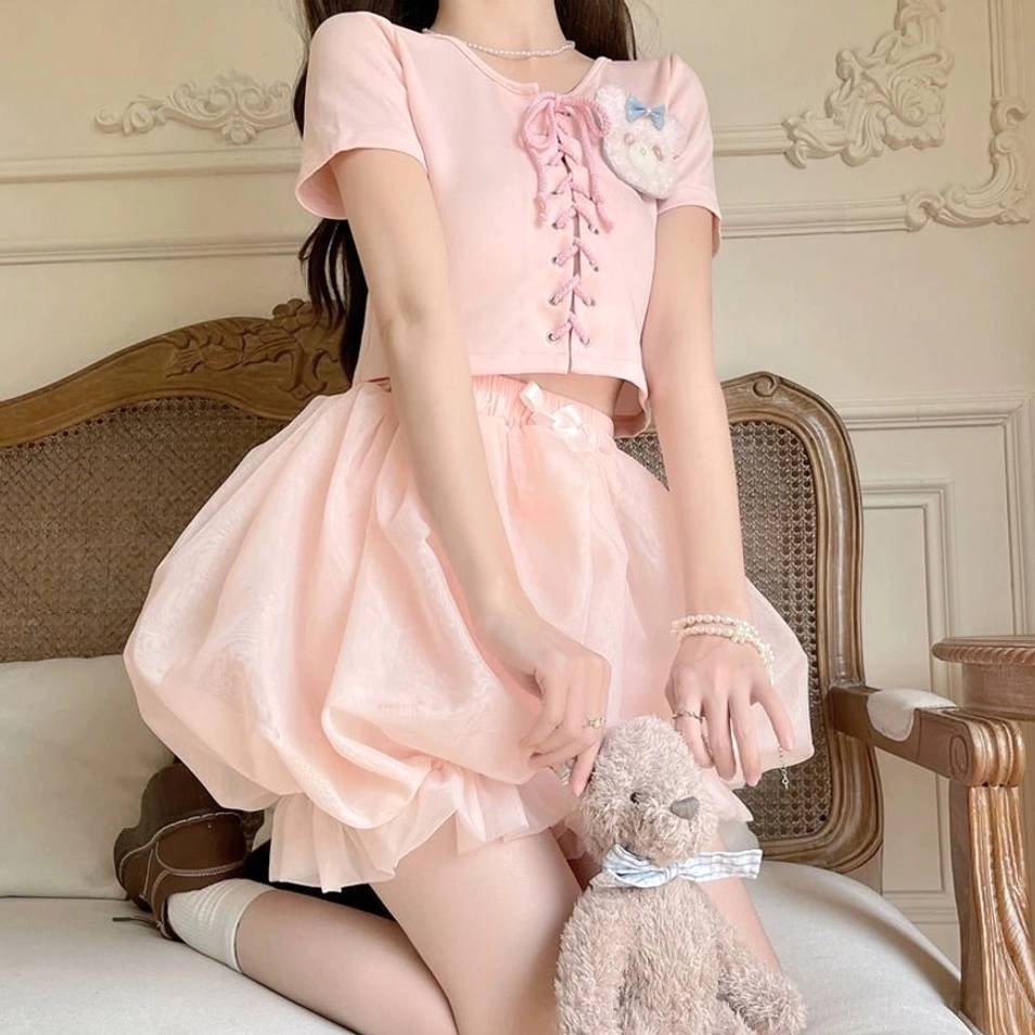 Pink sweet lolita bloomers coordinate with matching ruffled camisole and decorative accessories full outfit styling view