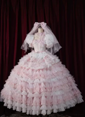 Pink monochrome sweet lolita bridal gown set displayed on dress form against red velvet curtain backdrop, showcasing multi-layered ruffle tulle ballgown silhouette, puff sleeves, beaded corset bodice, matching headbow and bridal veil