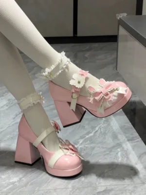 Side close-up view of pink patent leather sweet lolita chunky heel shoes on model wearing white ruffled ankle socks with flower bow decorations and block heels on marble floor