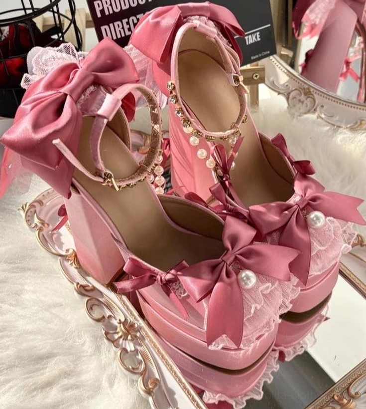 Pair of pink sweet lolita chunky heel platform shoes with oversized satin bows and pearl accents on decorative tray with fur backdrop