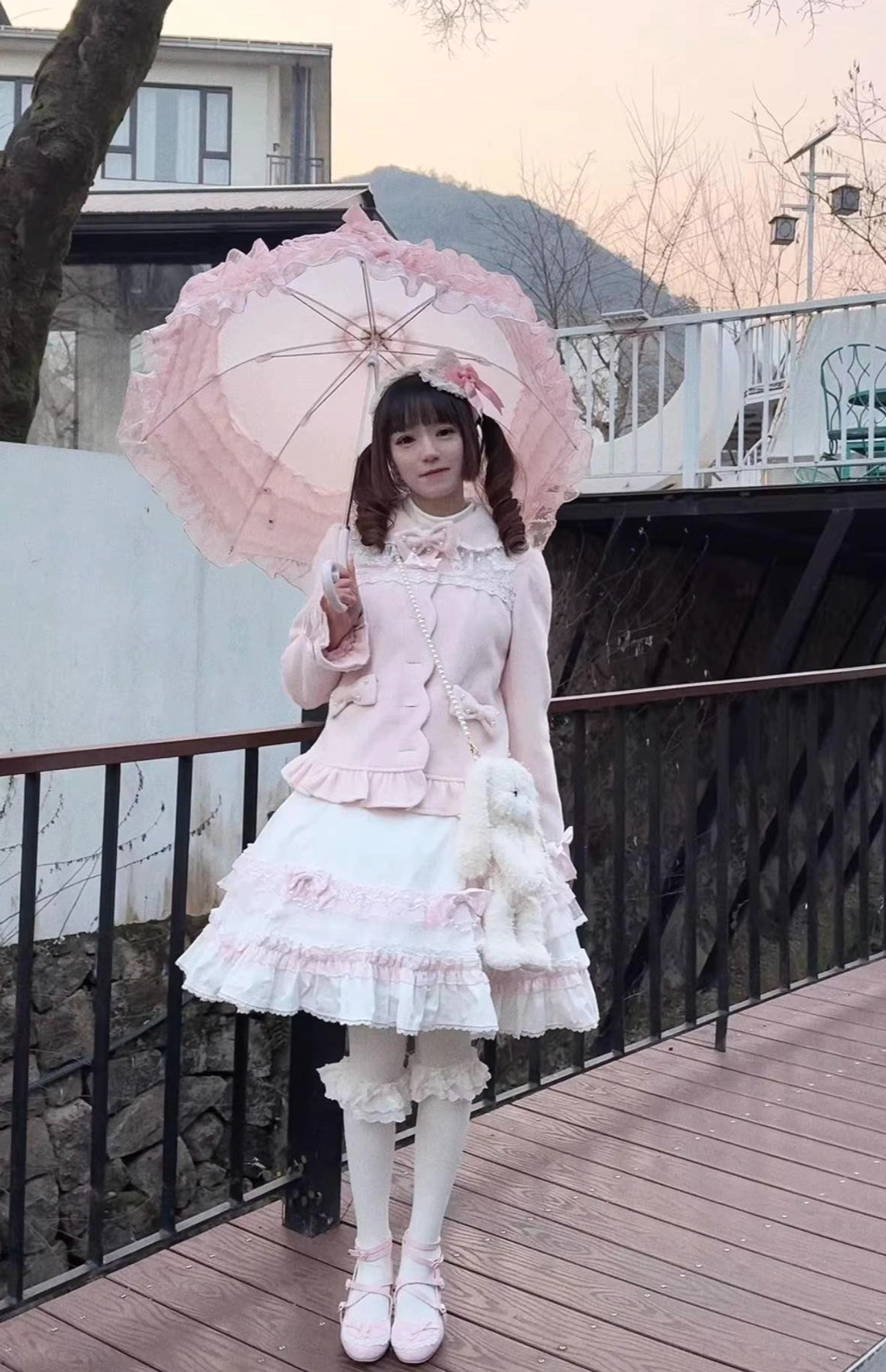 Pink sweet lolita coat and skirt set outdoor shot with pink lace-trimmed coat frilly white tulle skirt pink parasol and plush doll