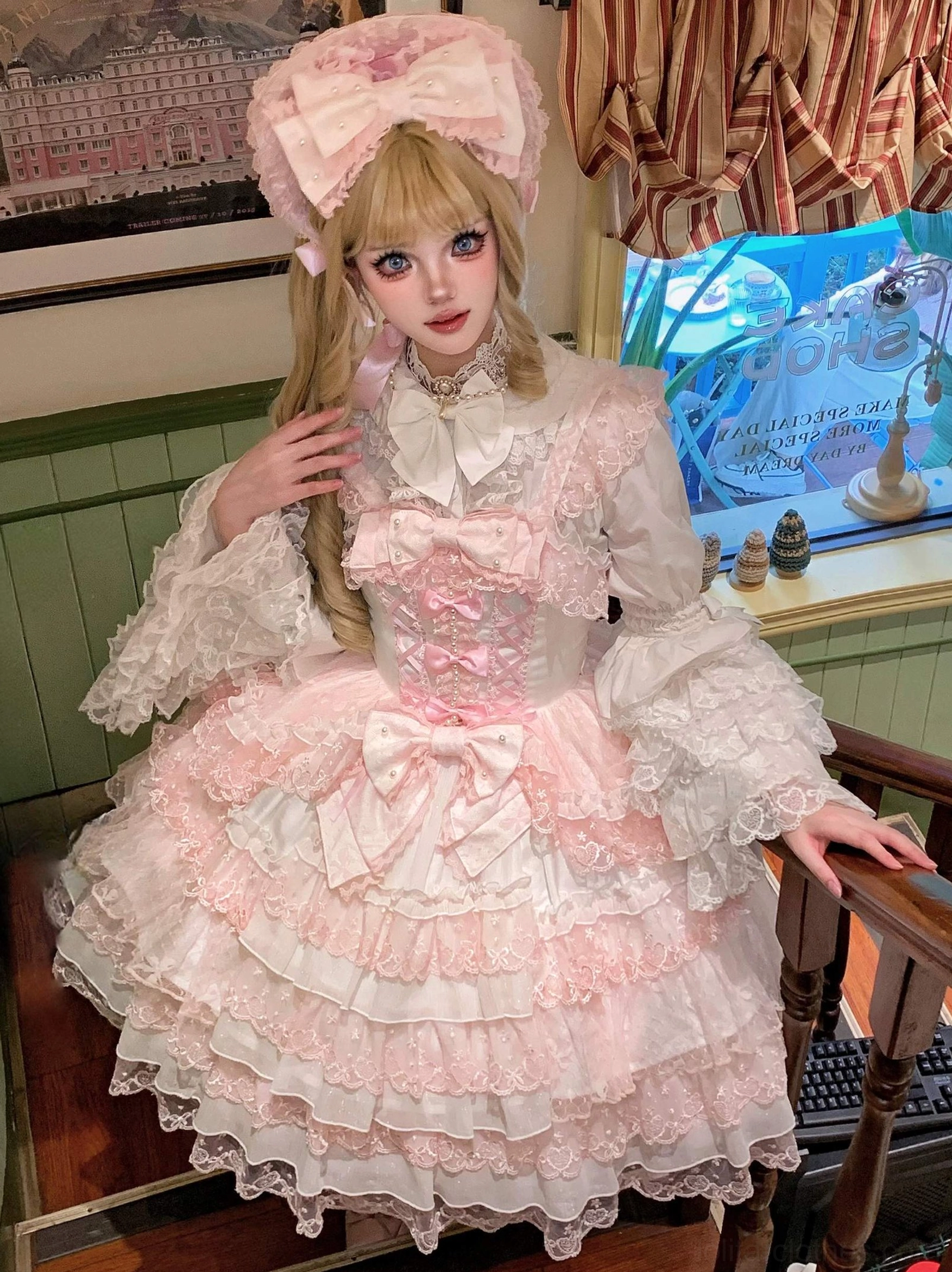 Pink Sweet Lolita dress with head accessory close-up front standing shot on staircase showing tiered ruffle lace hem, front decorative bows, frilled flared sleeves, high neck bow detail