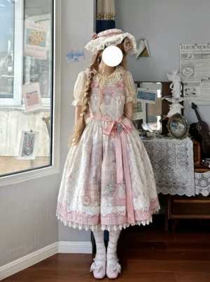 Pink sweet lolita JSK dress with fairy tale print and scalloped lace edges, front view with model wearing matching inner blouse and coordinating accessories in vintage-inspired study setting