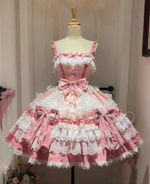 Pink sweet lolita JSK dress front flat view on mannequin showing layered lace trims, front waist bow, and side decorative bows with pink-white color scheme
