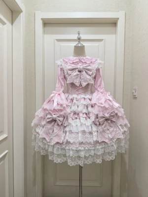 Pink Sweet Lolita JSK dress suit with white lace blouse displayed on mannequin showing front tiered ruffles design and decorative bow