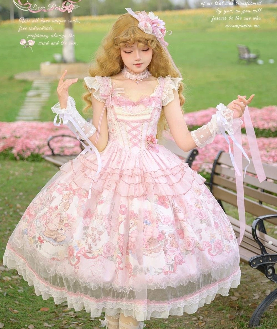 Pink sweet lolita jumper skirt three-quarter front view model with curly blonde hair lace gloves and tulle overlay skirt design detail