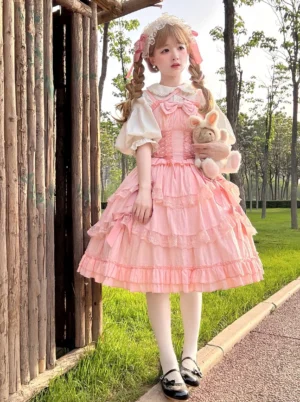Pink Sweet Lolita jumper skirt dress set with corset lace-up waist and puff sleeve blouse styled in park outdoor shoot