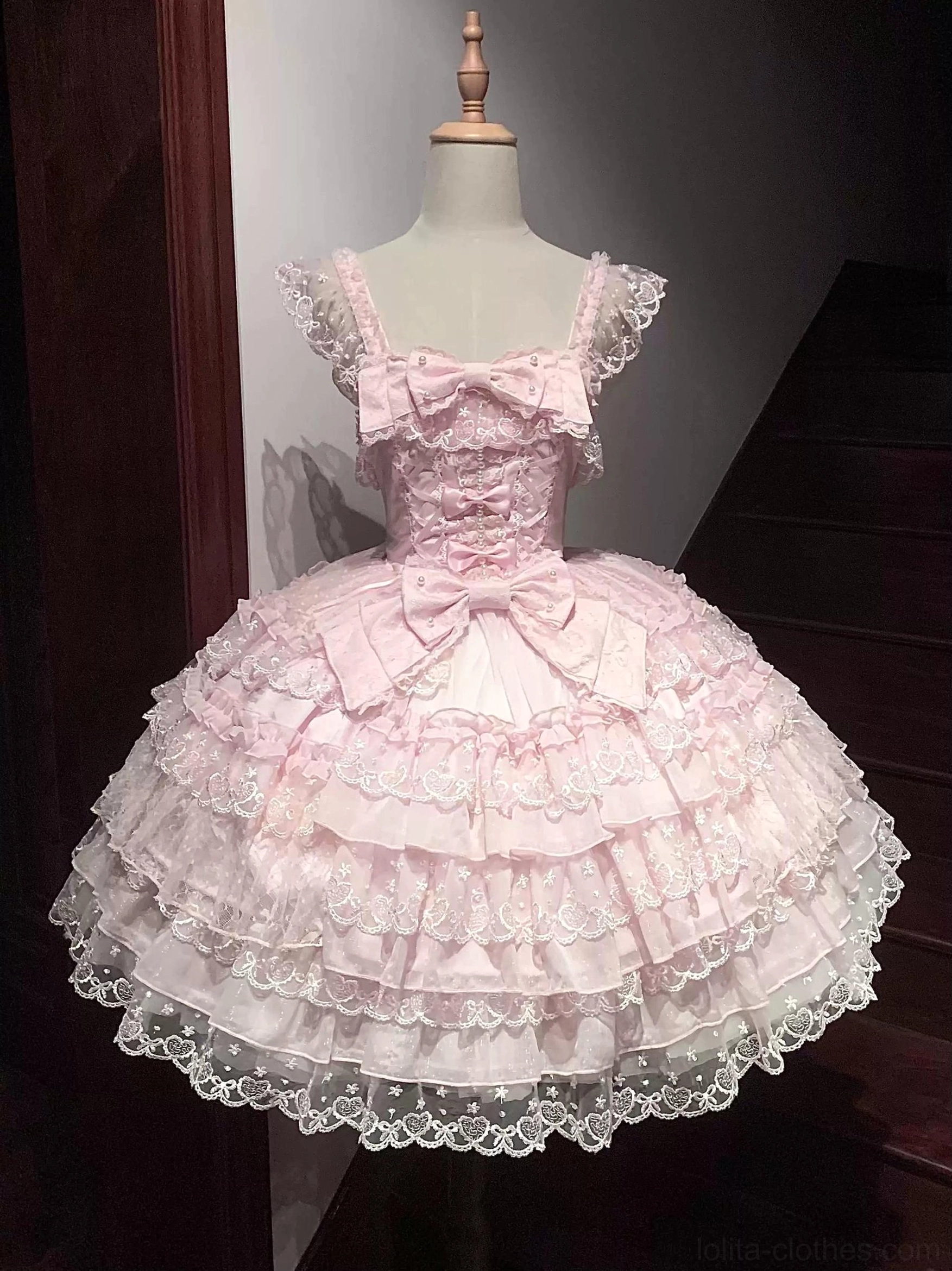 Pink Sweet Lolita JSK dress on dress form front full-body studio display with tiered ruffle lace hem, square neckline with front bow, shoulder straps, and large waist bow