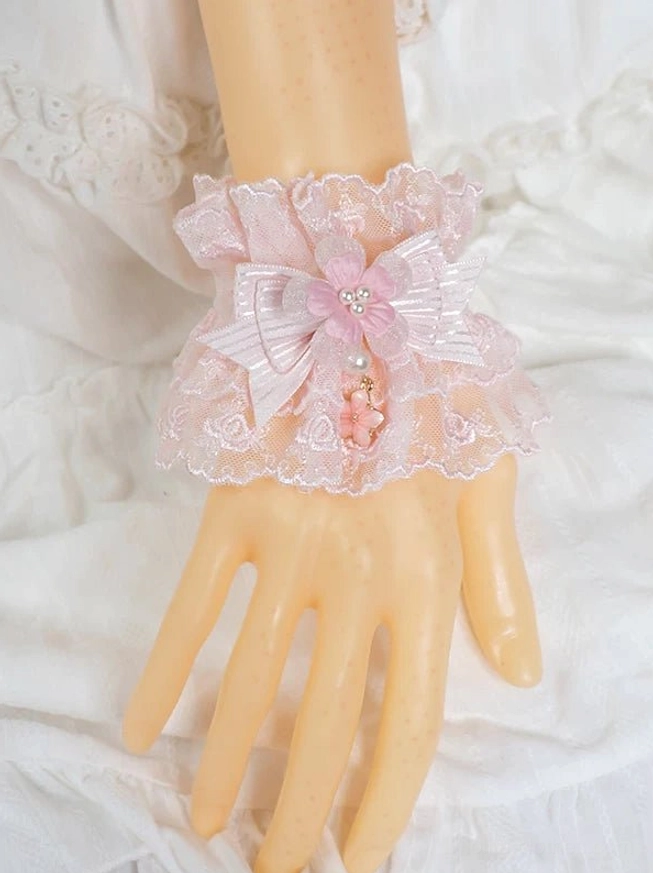 pink sweet lolita wrist cuff close-up on mannequin hand front view with floral lace, striped satin bow, and flower pearl drop tassel detail