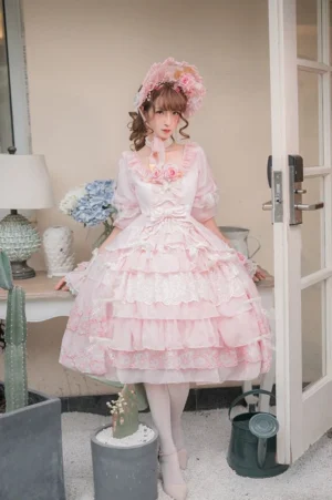 Pink Sweet Lolita one-piece OP dress with tiered ruffle hem, half puff sleeves, and floral lace neckline decoration, front flat view