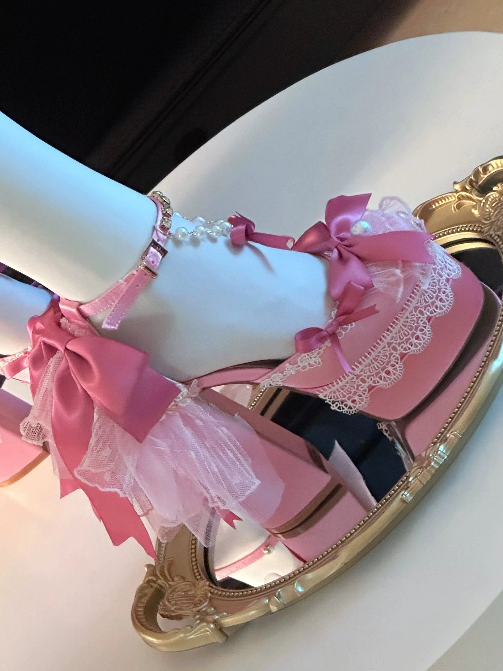 Pink sweet lolita platform heels with tulle overlay detail and satin bow, lace front trim pearl ankle bracelet, mannequin foot side close-up