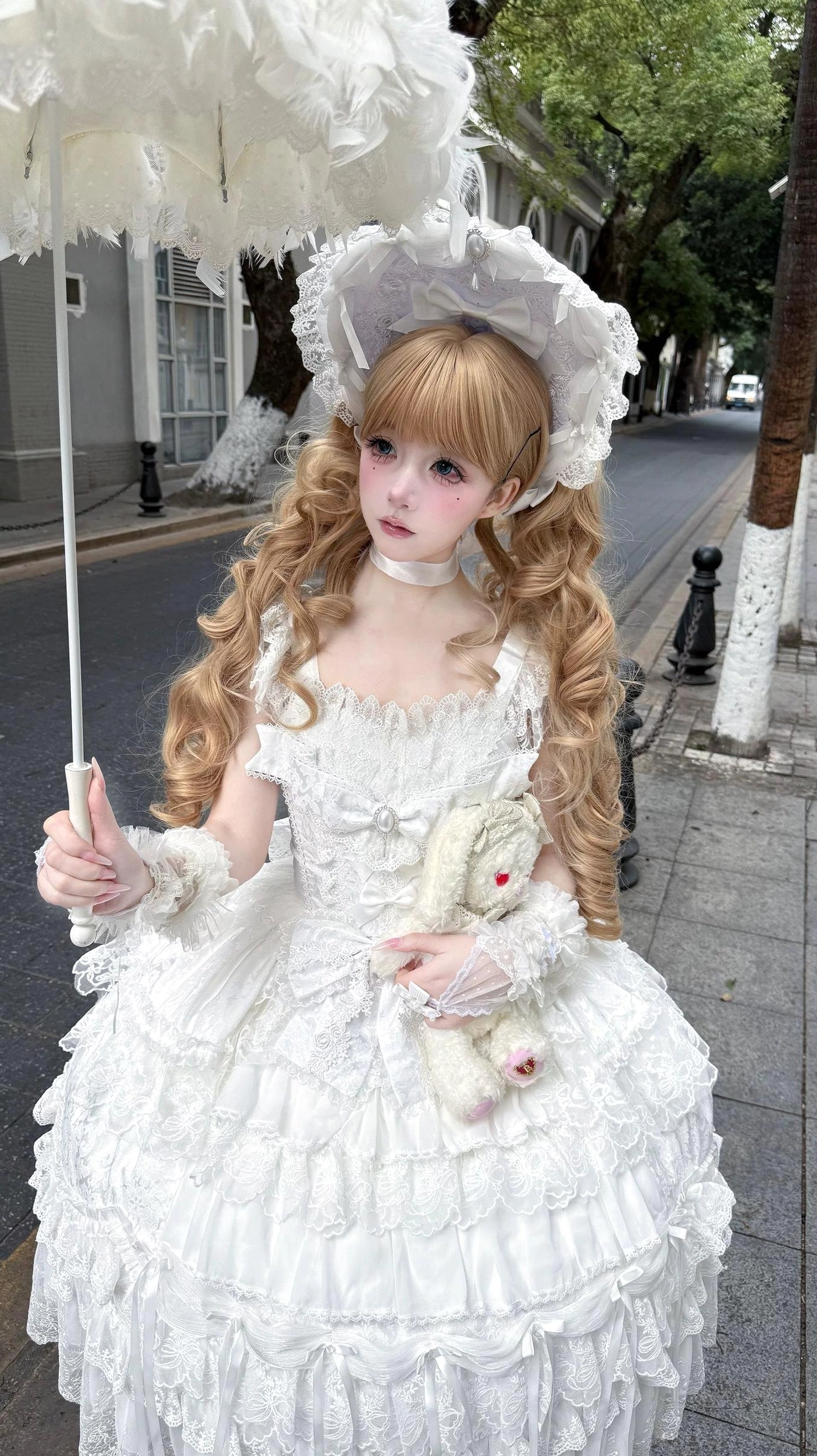 Pink sweet lolita tiered JSK dress with satin ribbon bow decorations and delicate lace embellishments full cake skirt