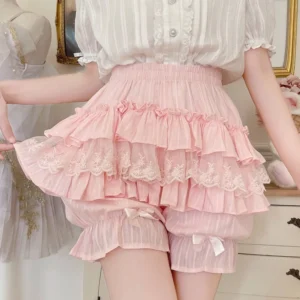 Pink sweet lolita tiered ruffle bloomers with elastic waist and lace trim, front view worn with striped chiffon blouse in vintage bedroom setting