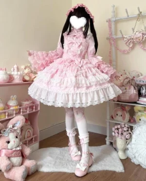 Pink sweet wedding lolita JSK dress full-body front view with detachable bow and multi-layered lace trim worn by model in vintage princess room setting