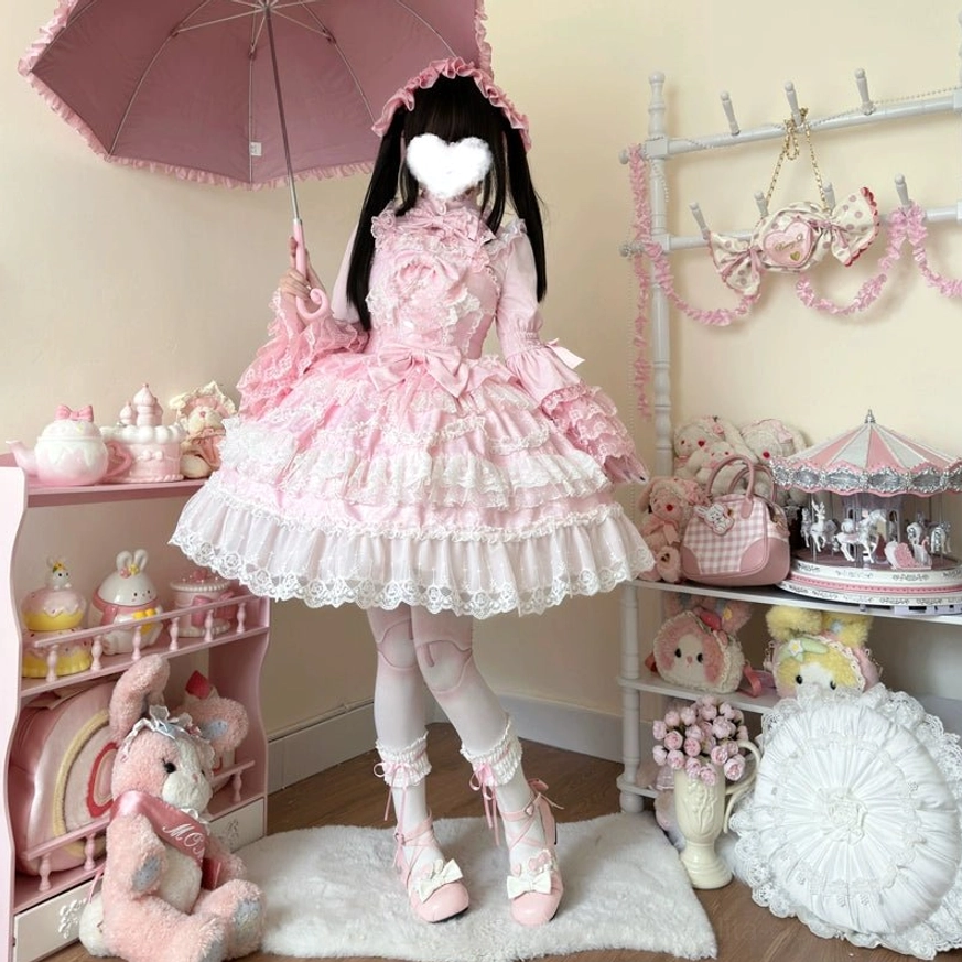 Pink sweet wedding lolita JSK dress full-body front view with pink parasol prop displaying stand collar and flared lace sleeves