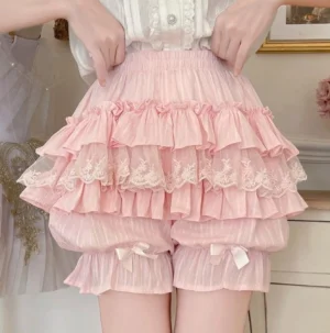 Pink layered ruffle sweet lolita cotton bloomers with delicate lace trim satin bows leg cuffs elastic waistband worn by model vintage indoor scene front close-up view