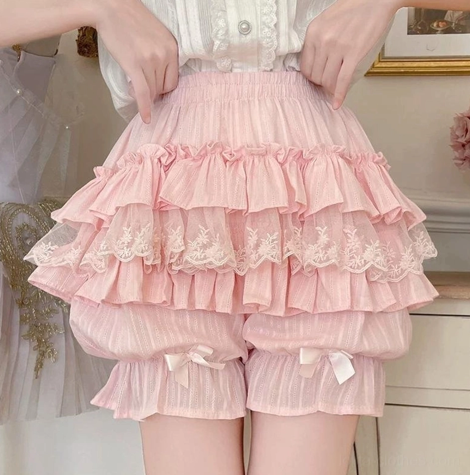 Pink layered ruffle sweet lolita cotton bloomers with delicate lace trim satin bows leg cuffs elastic waistband worn by model vintage indoor scene front close-up view