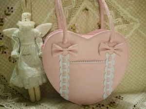 Soft pink heart-shaped Lolita tote bag with matching pink bows and white ruffled ribbon trims vintage lace setting