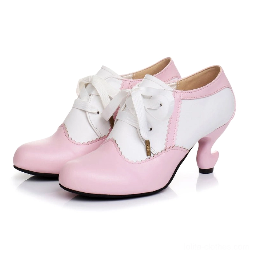 Pink and white dual color blocking Lolita high heel shoe flat lay product shot showing scalloped edge trim, curved spool heel, ribbon lace closures with metal tips, neutral background