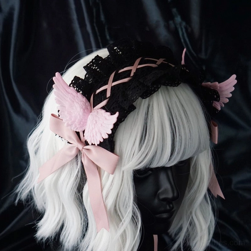 Pink wing version gothic lolita hairband front display on white mannequin head with black lace base pink crisscross straps pink wing ornaments