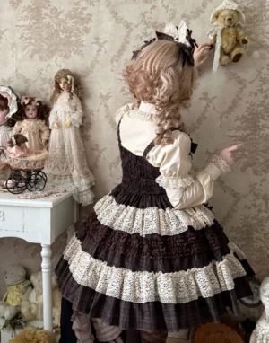 Back overhead view of plaid lolita jumper skirt with shirred back panel, multi-tiered ruffle layers, and cream lace trim with teddy bear themed hair accessory