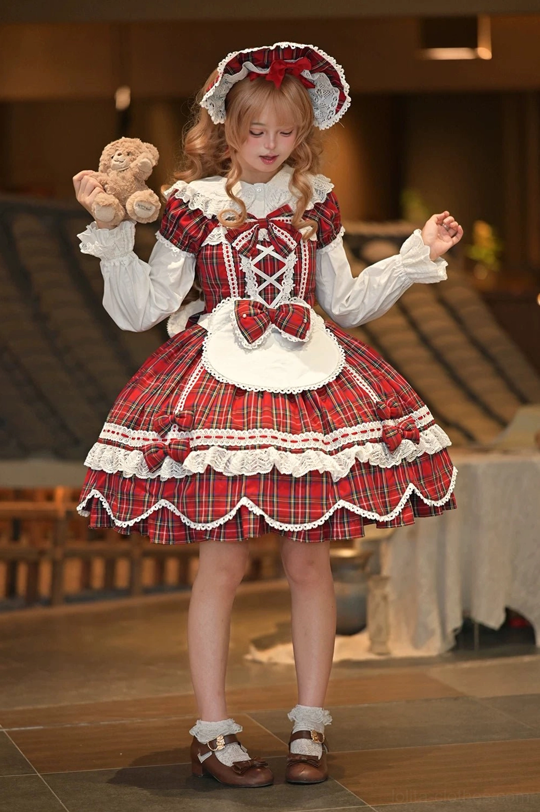 Plaid lolita OP dress three-quarter view showing dimensional bow design, petal hem layers, and Old School aesthetic proportions