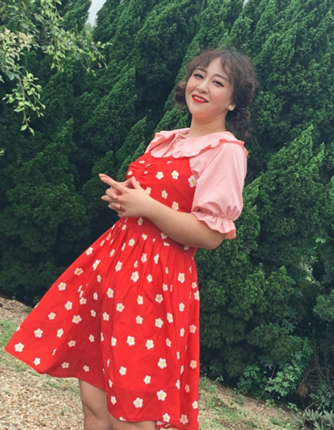 Plus-size model in red polka dot suspender dress with pink peter pan doll collar lolita blouse with puff short sleeves standing on outdoor path beside pine forest showing front view full body styling