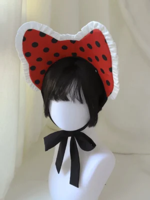 Red polka dot cat ear lolita headband with white ruffled edge trim and black cat ears, displayed on mannequin with short black wig, front close-up view showing intricate details