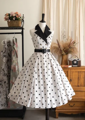 Classic polka dot halter-neck JSK dress in black and white, displayed on dress form showing contrast black lapel collar, structured waist belt, and voluminous skirt silhouette