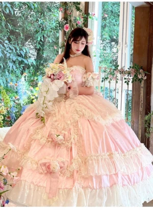Three-quarter front shot of pastel pink princess bridal lolita gown with floral rose decorations and ruffled ball skirt
