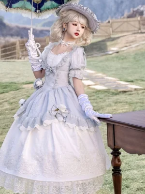 Side profile three-quarter full-body view of princess lolita OP dress showcasing tiered lace hem skirt and embroidered white panel with fitted corset waist on model holding retro umbrella outdoor grassland setting