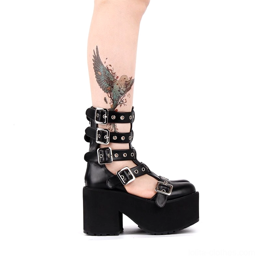 Side rear lower leg view of platform gladiator boots on tattooed model, showcasing silver adjustable buckles, thick platform heel, and glossy black patent leather finish