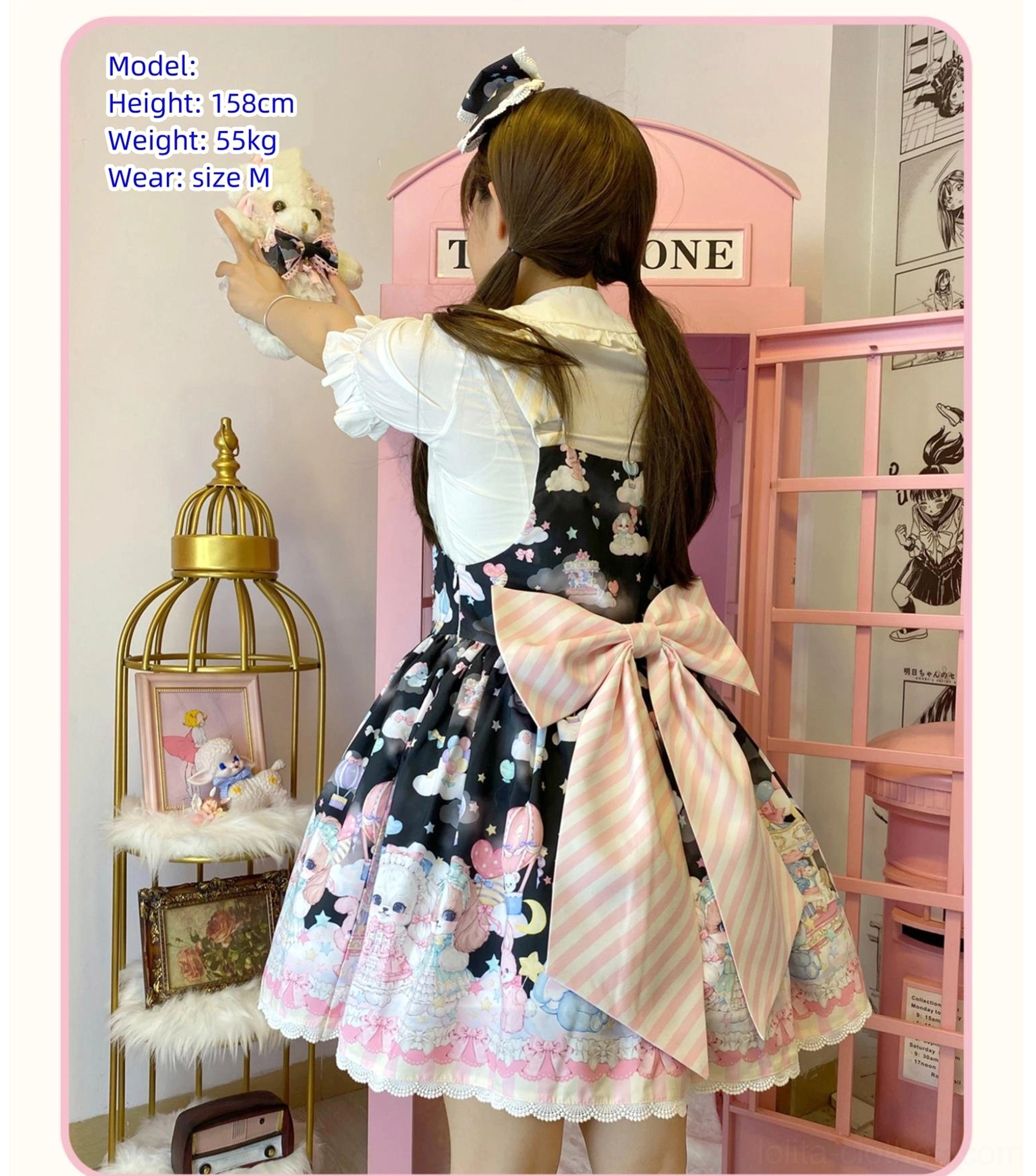 Black puppy themed Lolita salopette back full body view model height 158cm wearing size M showing huge striped pink back bow ruffled skirt hem telephone booth scene