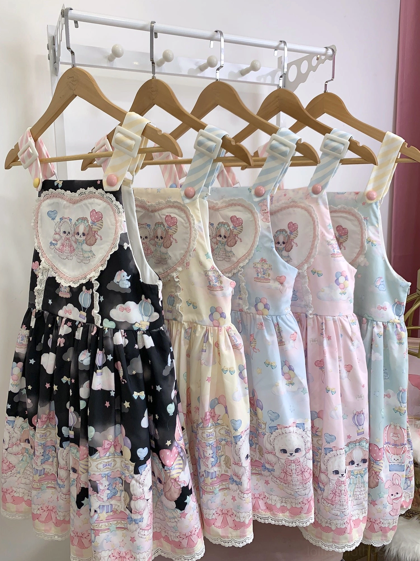 Puppy Dreams Sweet Lolita salopette JSK in multiple pastel color options including pink mint green blue light yellow and black pink hung on wooden hangers overhead display view