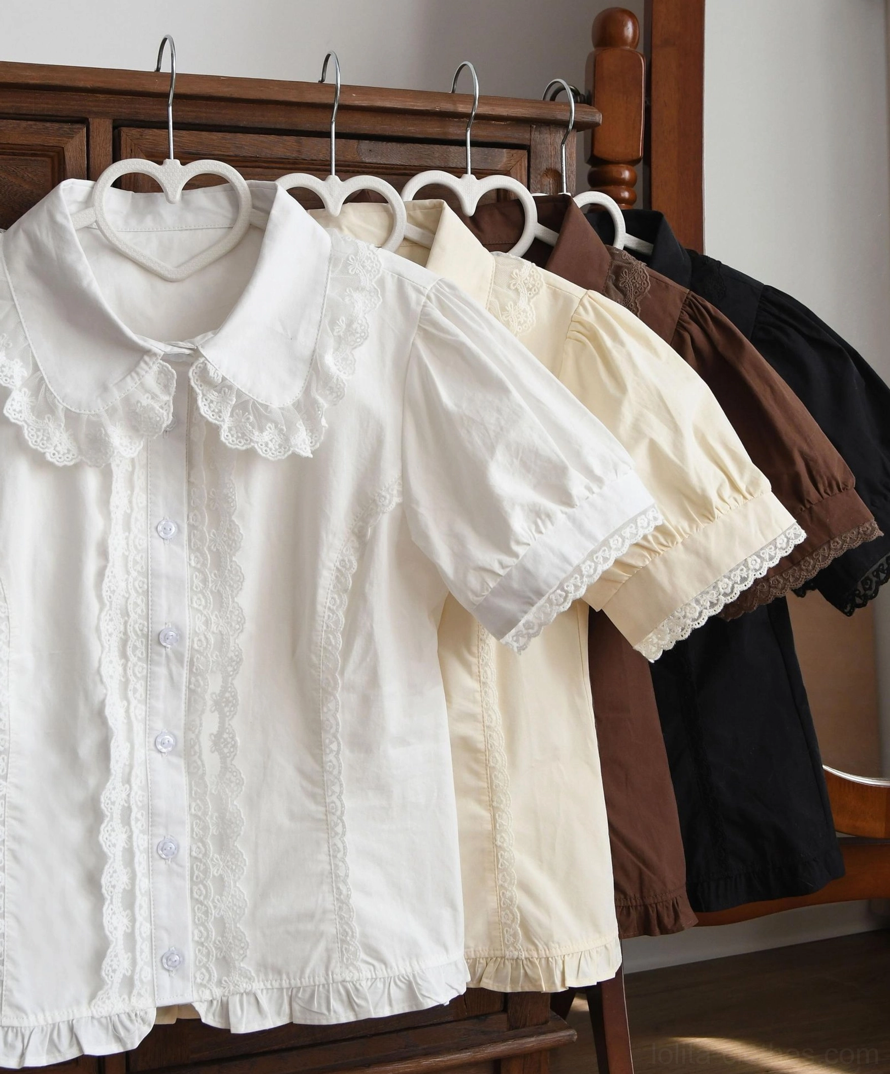 Pure white vintage Lolita short-sleeve blouse with lace ruffled Peter Pan collar simple cuff trim and neat straight hem flat lay wooden table display
