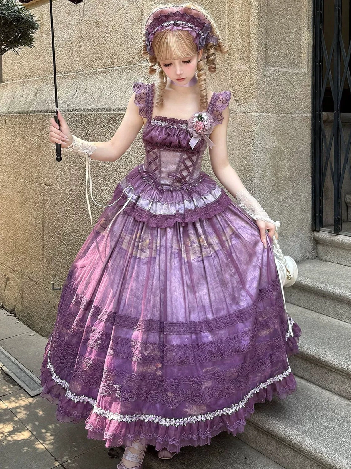 Sleeveless purple classic lolita two-piece dress with square bodice, layered lace skirt hem, and vintage umbrella prop, side view on outdoor stone stairs
