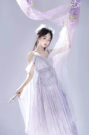 Three-quarter front view of purple Lolita formal dress with detachable sheer cape and floral fabric background