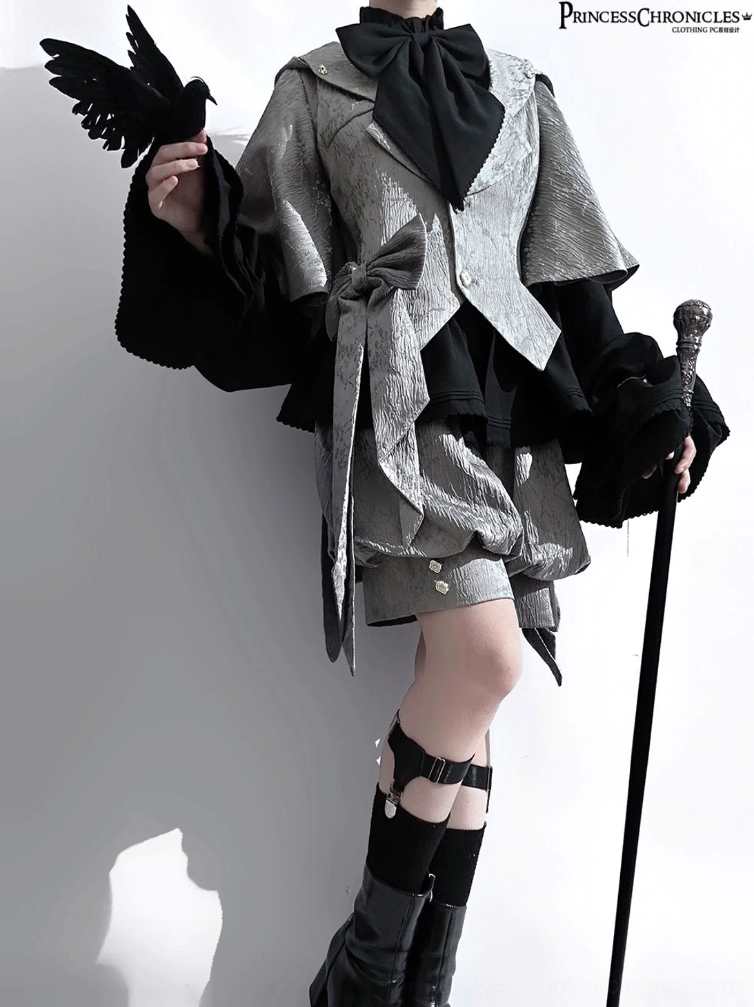 Rabbit ear glacier grey ouji lolita suit front three-quarter view with black crow prop and walking cane