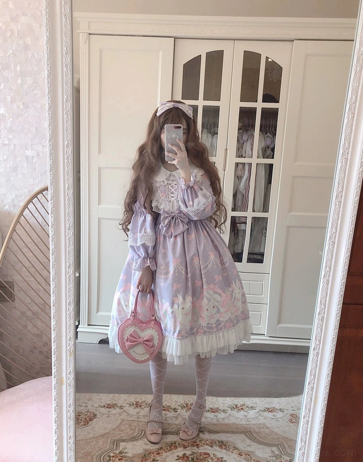 Pastel purple rabbit print Lolita one-piece dress full side profile on model wearing white stockings, pink heart-shaped handbag, long puffed sleeves, elegant home wardrobe background