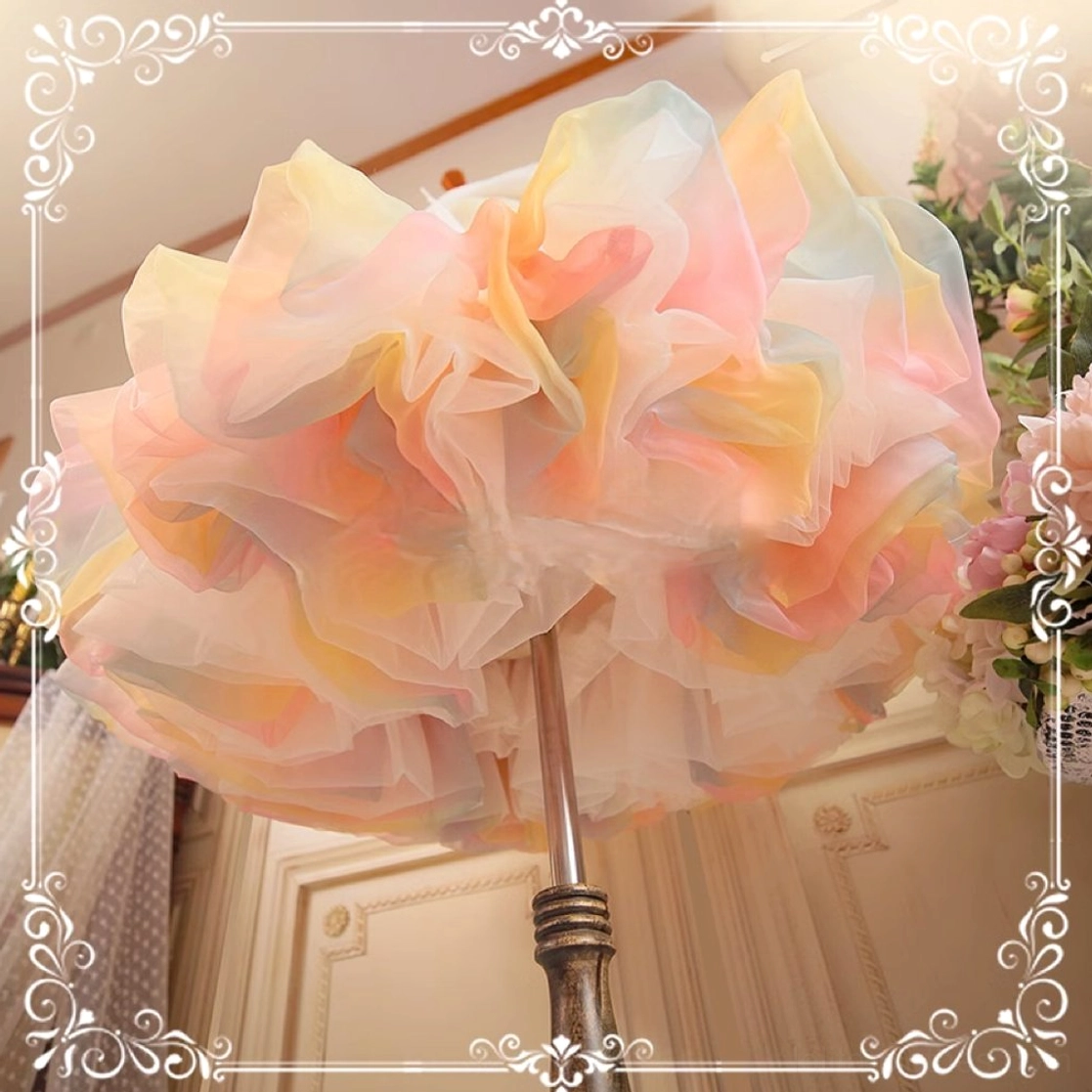 Close-up detail of lolita petticoat hem and ruffles, showcasing layered airy tulle construction with soft pastel color gradient and fluffy texture