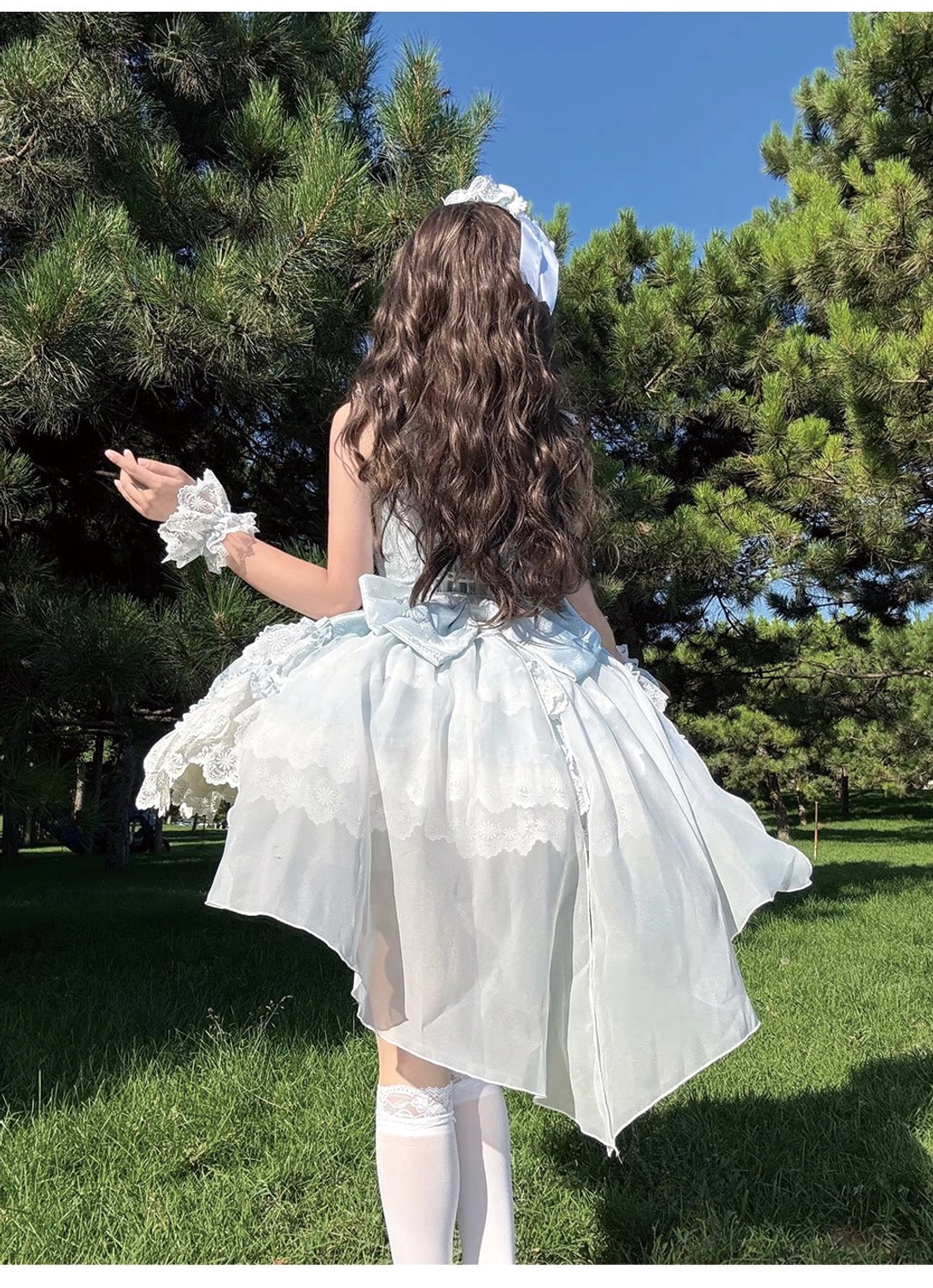 Realm of Sea Moon JSK back view model pine tree grassland asymmetrical petal hem ruffled lace white stockings matching wrist cuffs bow detail