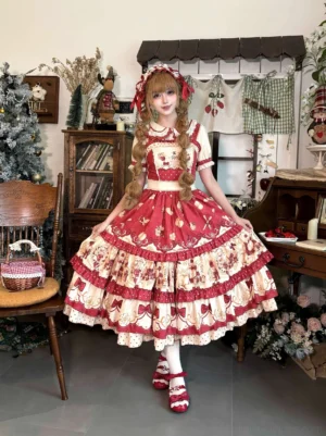 Red apple sweet lolita JSK dress with tiered ruffled hem and cream fruit print worn by blonde model in vintage study room setting with matching bonnet and apron