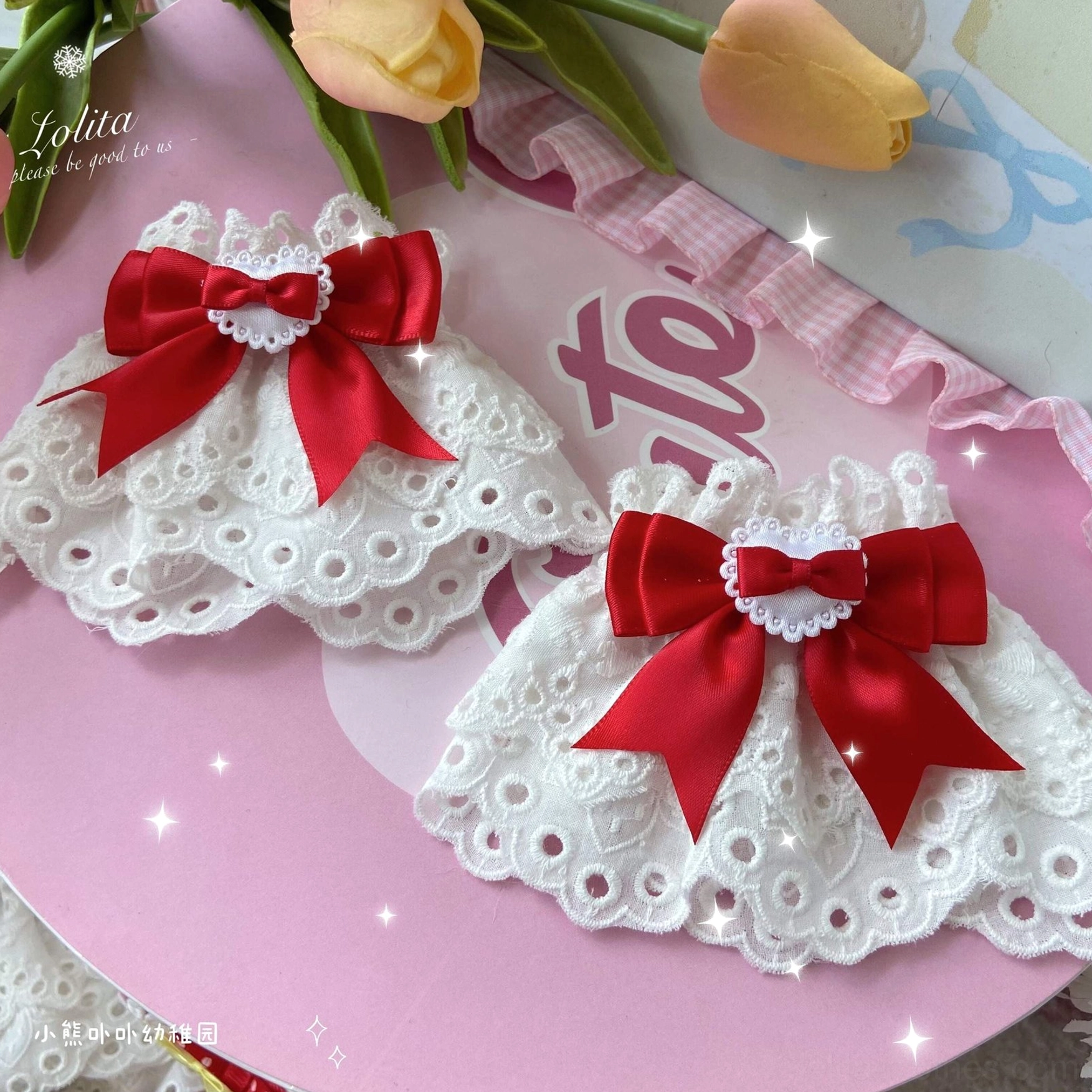 pair of red bow lace wrist cuffs with heart details on pink background with tulips and text decoration