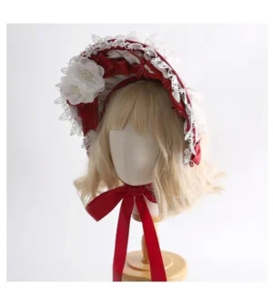 Front angle of festive Lolita bonnet hair accessory featuring ruffled white lace edge, red satin base, fabric flower decorations, and neck fastening ribbon detail