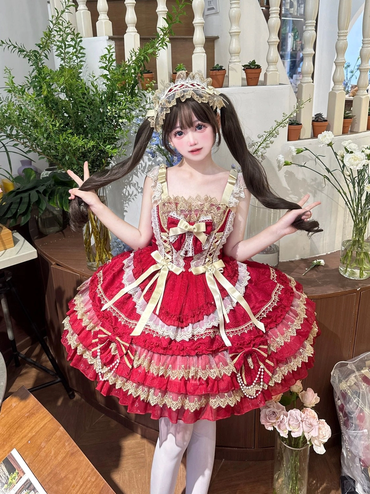 Red and gold sweet lolita jumper dress front close-up three-quarter view tiered ruffles gold lace trims large front satin bows pearl pendants