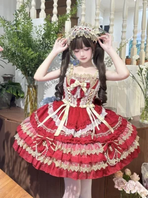 Red and gold sweet lolita jumper dress front three-quarter close-up view featuring tiered ruffles pearl bows and gold lace trims on Asian model with twin tails