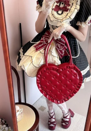 Red heart-shaped sweet lolita handbag close-up mirror shot with model wearing vintage sweet lolita dress and matching hair accessories